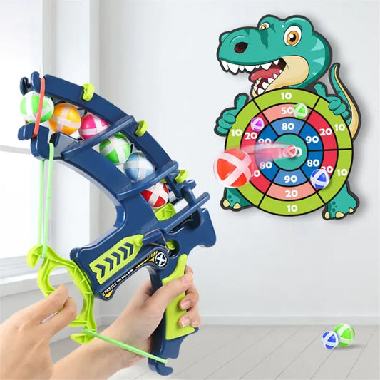 Toy slingshot with colorful balls and a dinosaur-themed dartboard on a white background