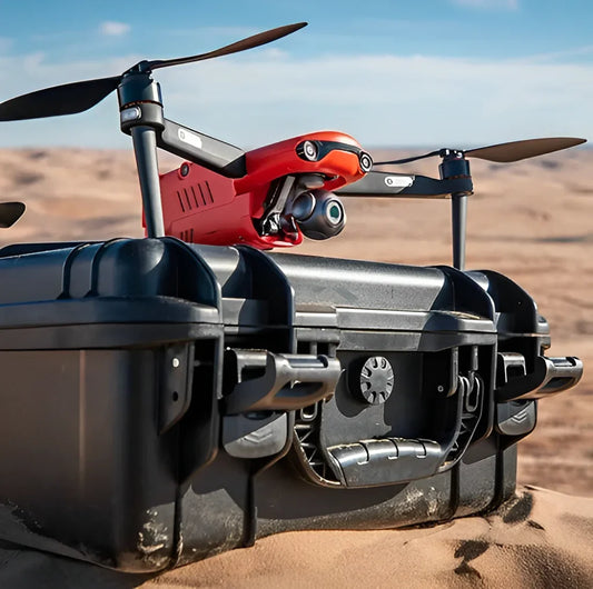 Red and black drone on a sand dune with a clear sky